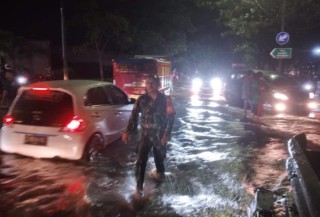 Babinsa Koramil 0830/06 Benowo Berjibaku Atur Kemacetan Lalu Lintas Saat Diguyur Hujan Lebat