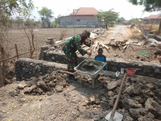 Karya Bhakti Babinsa Koramil Wringinanom, Bantu Warga Dalam Pembangunan Selokan Air di Jalan Desa Watestanjung