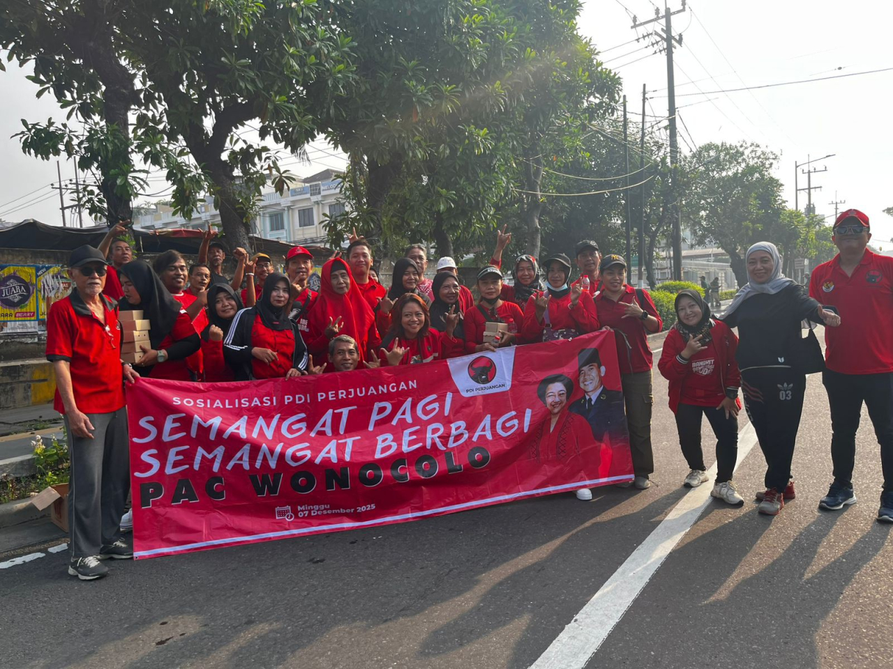 jajaran pengurus PAC Wonocolo menggelar aksi sosial berupa pembagian nasi bungkus kepada warga serta pengguna jalan di kawasan Jl Raya Jemur Andayani