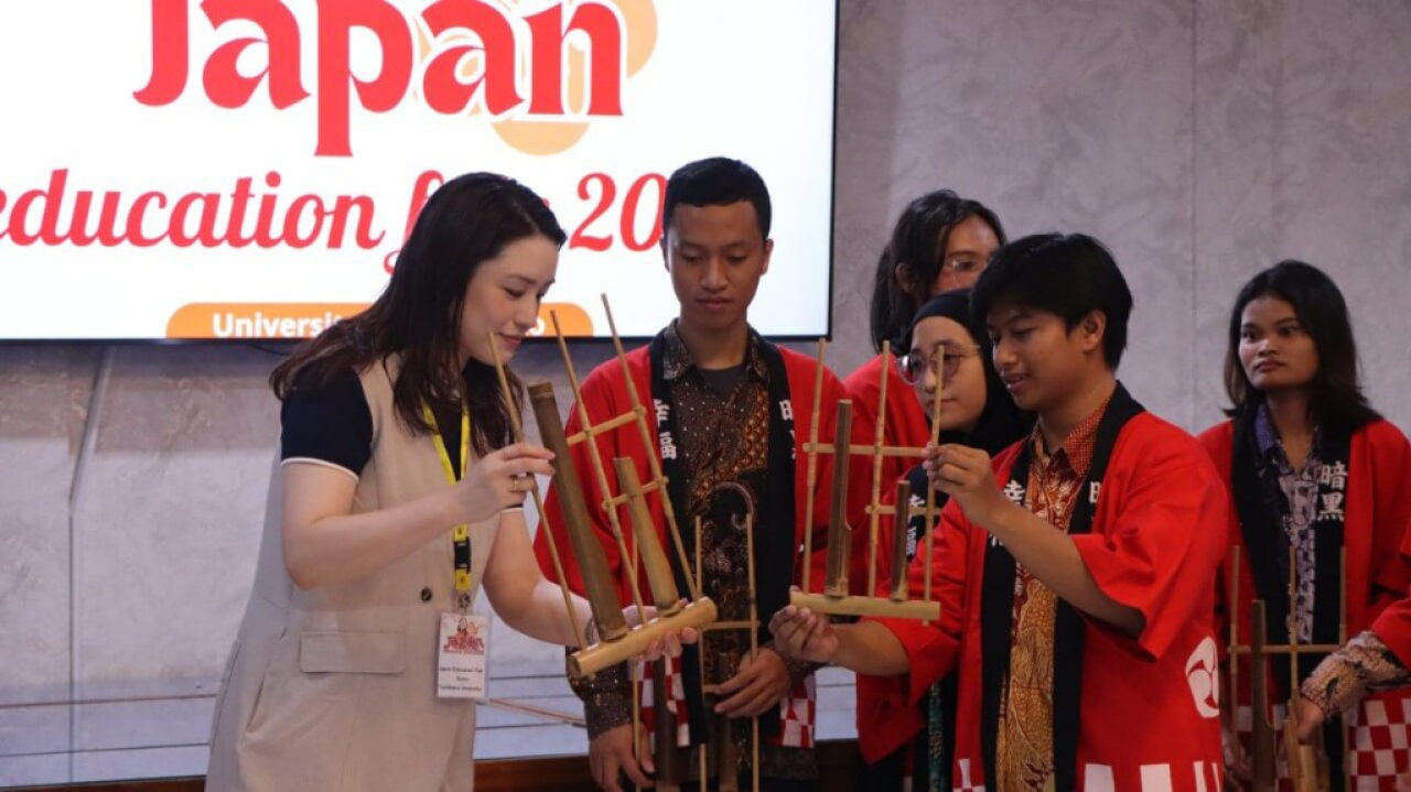 Delegasi License Academy Jepang belajar main angklung bersama mahasiswa Sastra Jepang Unitomo di Japan Education Fair 2026 Surabaya