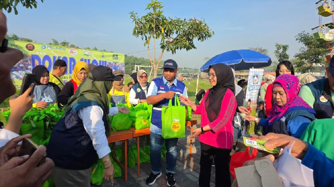 Sekretaris Perusahaan TPS menyerahkan paket pangan Program DOKAR kepada warga di Wisata Rakyat Balongpesapen Lakarsantri Surabaya