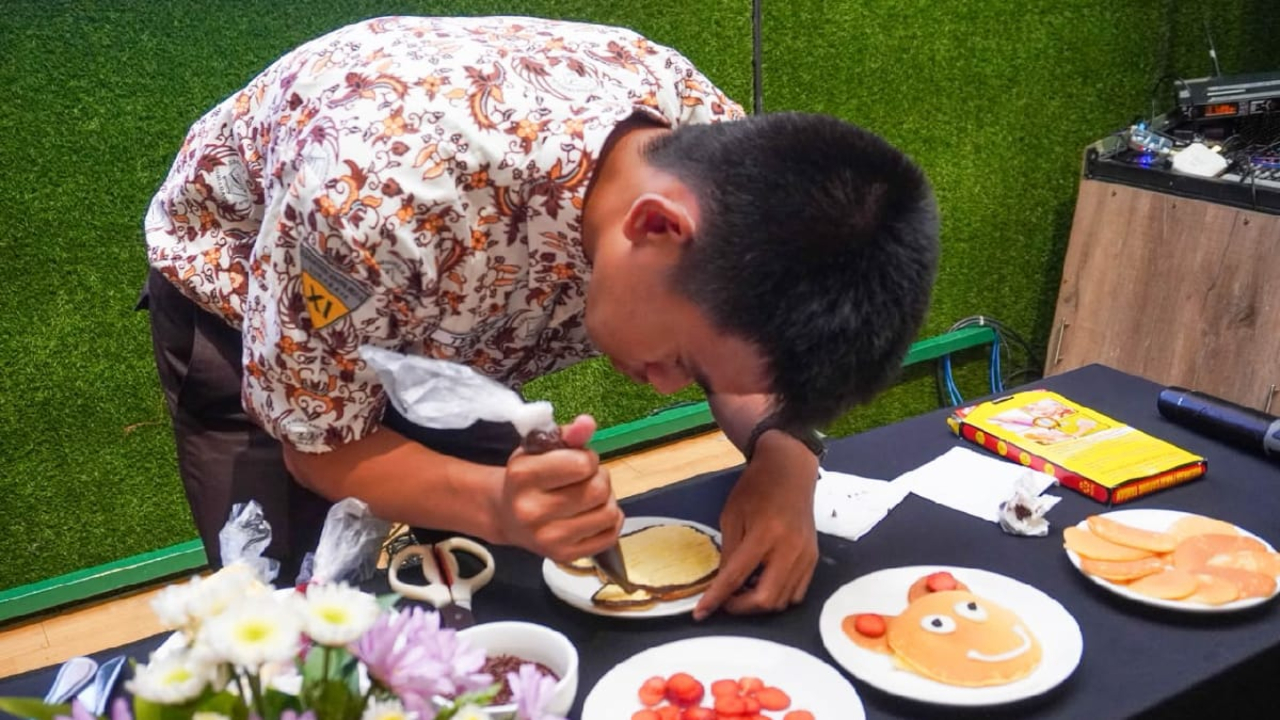 Siswa SMALB Karya Mulia menuangkan kreativitas dengan menghias pancake dalam perayaan Hari Batik Nasional 2026 di Mercure Surabaya Grand Mirama.