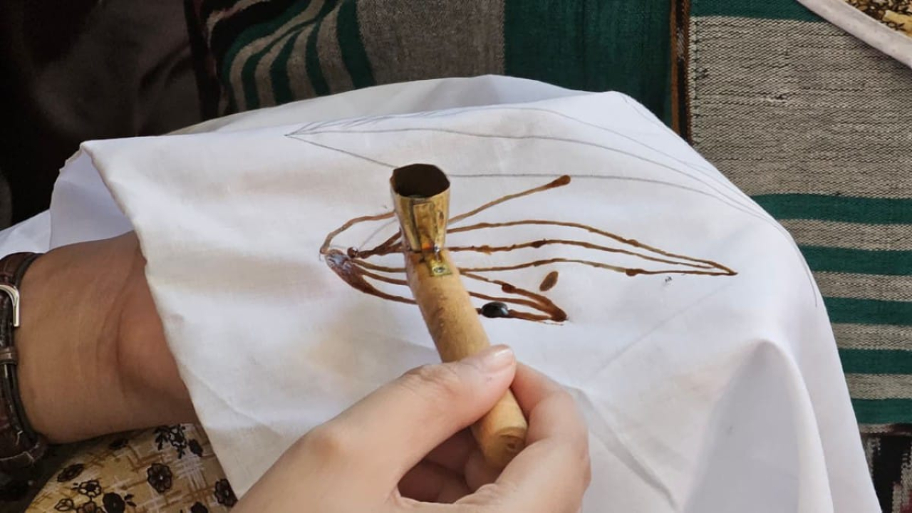 Seorang peserta mempraktikkan teknik mencanting dengan menggunakan canting untuk menorehkan malam di atas kain dalam kegiatan edukasi membatik di Stasiun Surabaya Gubeng.